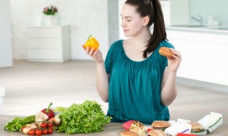 Woman with fast food and vegetables